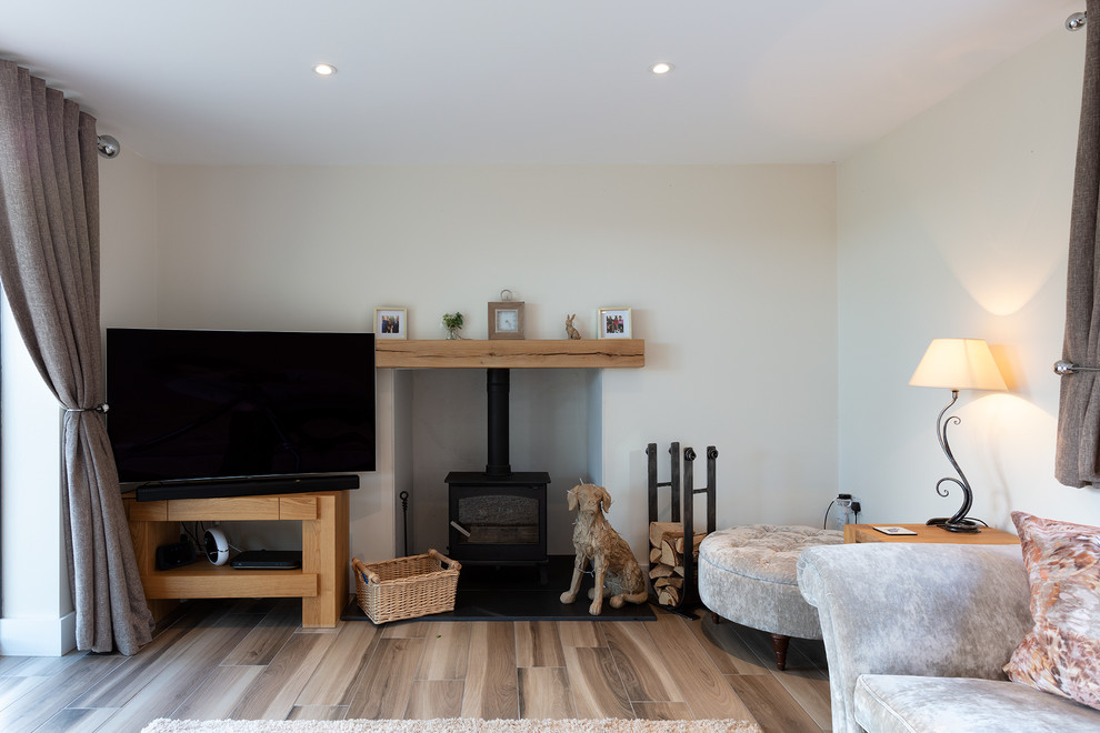 Example of a mid-sized classic living room design in Berkshire with a wood stove