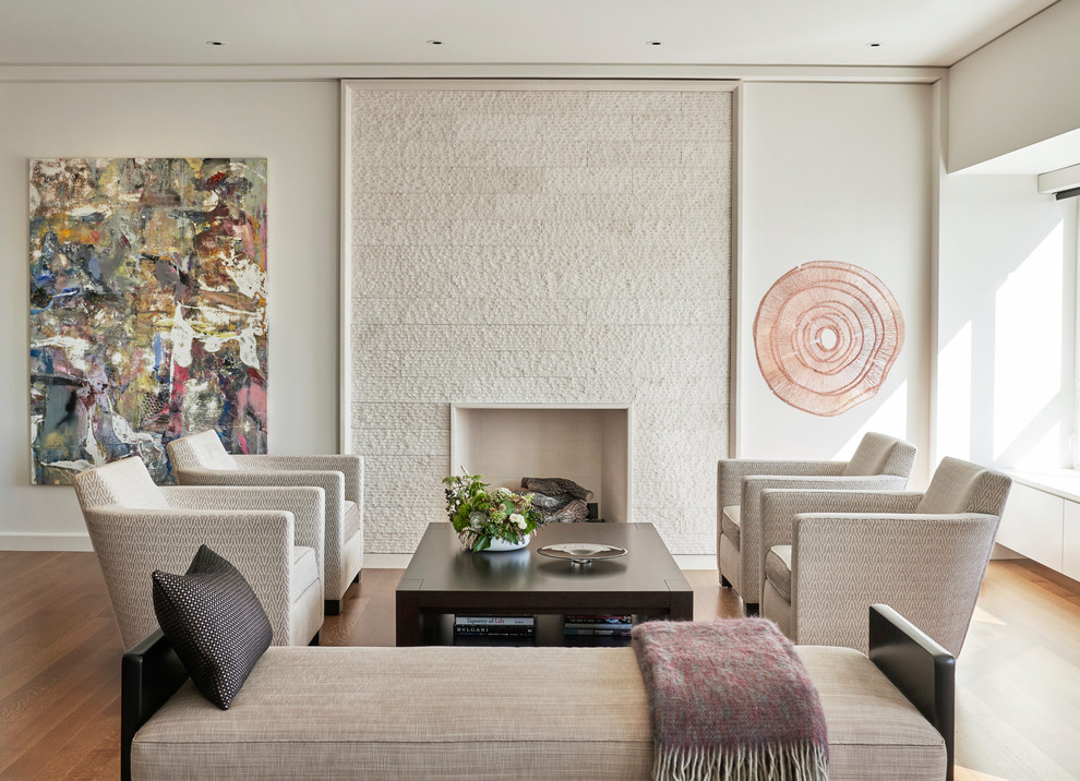 Diseño de salón actual con paredes blancas, suelo de madera en tonos medios, todas las chimeneas y suelo marrón
