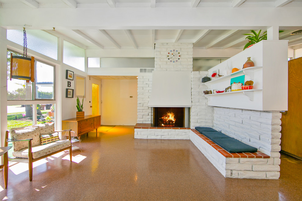 Design ideas for a midcentury open plan living room in Orange County with white walls and a brick fireplace surround.