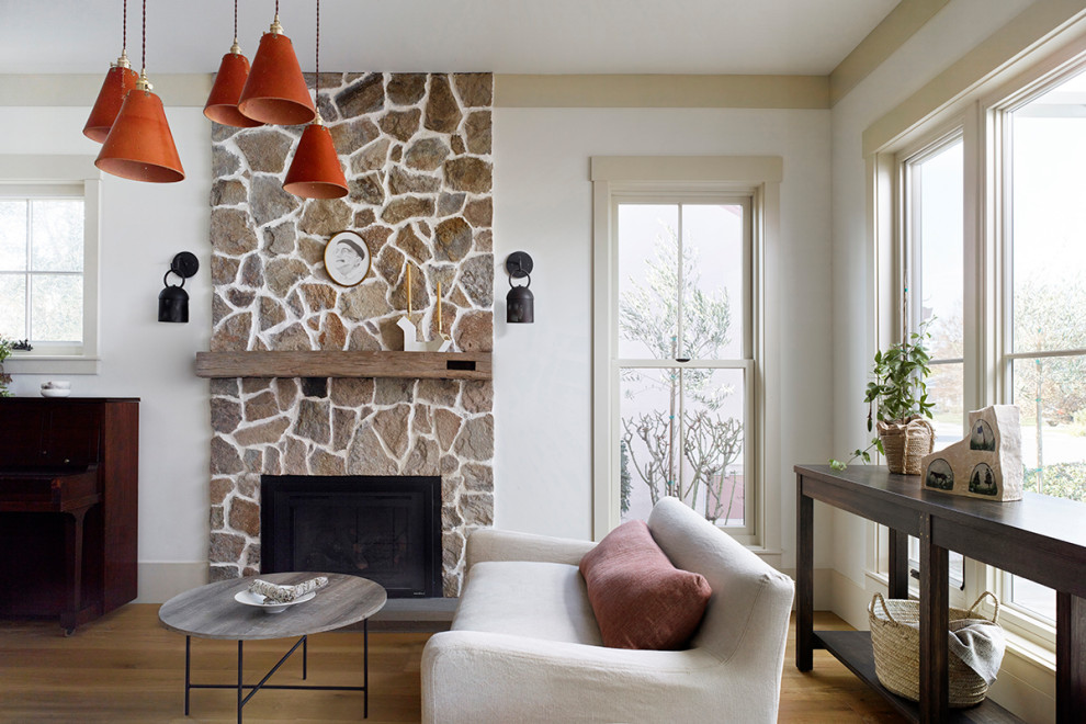 Inspiration for a mid-sized cottage medium tone wood floor living room remodel in San Francisco with a standard fireplace and a stone fireplace