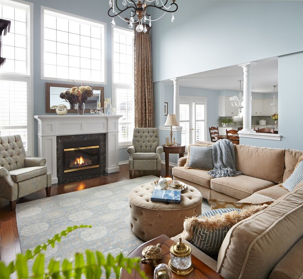 トロントにあるラグジュアリーな広いトラディショナルスタイルのおしゃれなリビング (青い壁、濃色無垢フローリング、標準型暖炉、木材の暖炉まわり、内蔵型テレビ、茶色い床) の写真