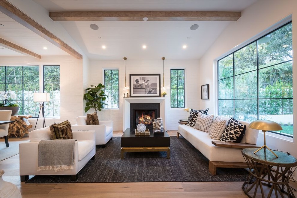 Idee per un soggiorno minimal con pareti bianche, parquet chiaro, camino classico e pavimento beige