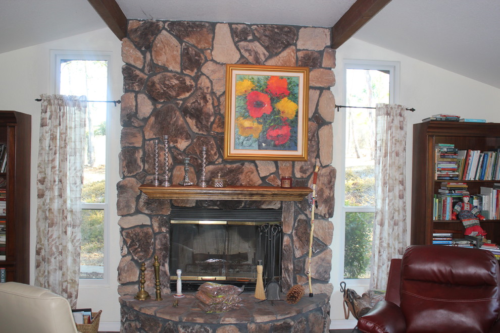 Diseño de salón para visitas cerrado rural de tamaño medio sin televisor con paredes blancas, suelo de madera oscura, todas las chimeneas, marco de chimenea de piedra y suelo marrón