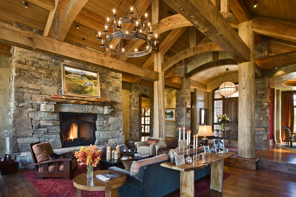 Exemple d'un salon montagne avec parquet foncé, une cheminée standard, un manteau de cheminée en pierre et éclairage.