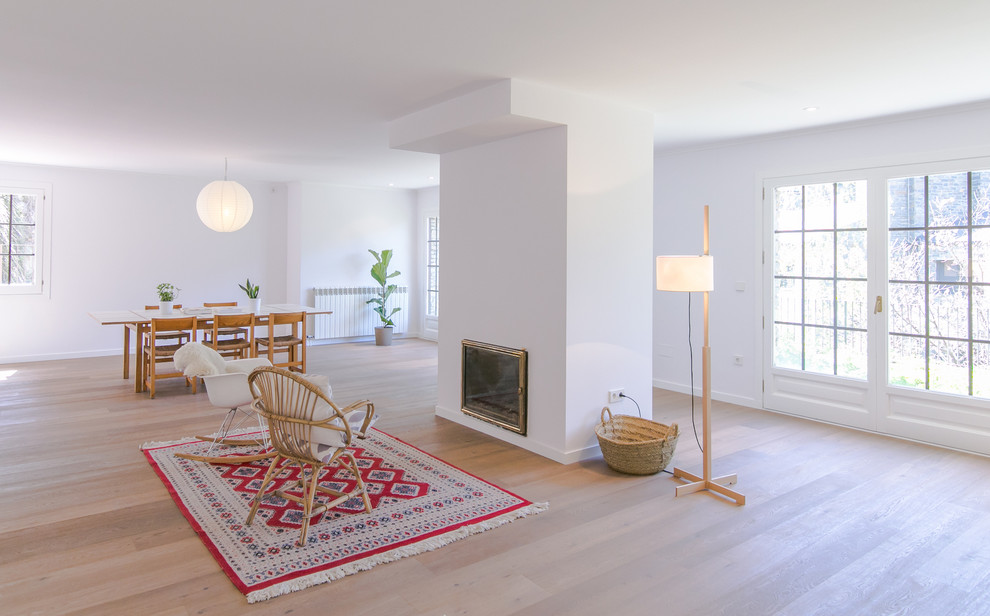 Стильный дизайн: большая парадная, открытая гостиная комната в скандинавском стиле с белыми стенами и паркетным полом среднего тона без камина, телевизора - последний тренд