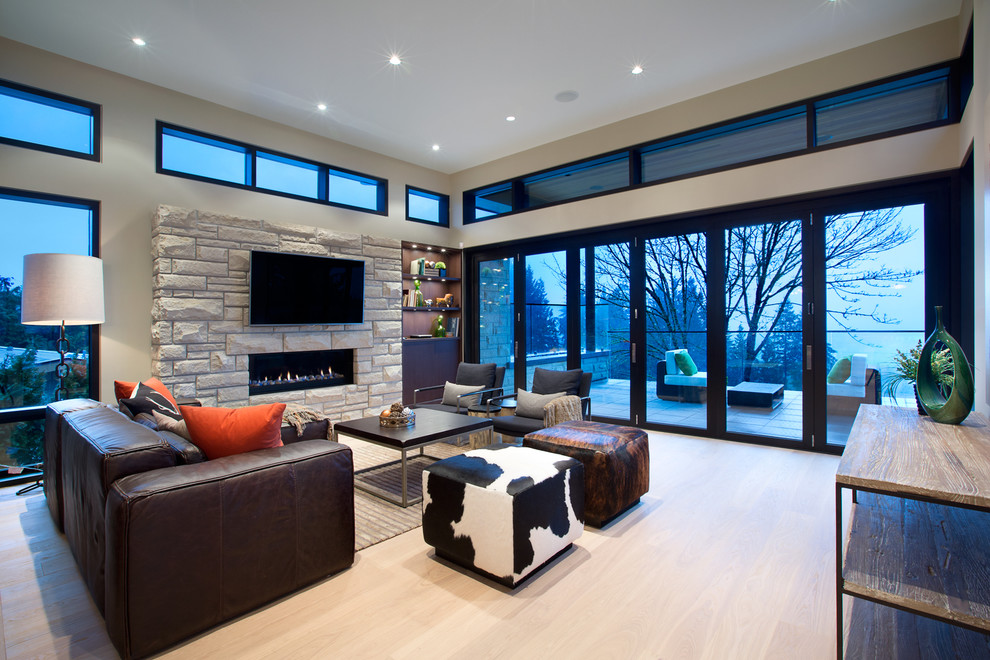 Foto di un soggiorno design con sala formale, cornice del camino in pietra e TV a parete