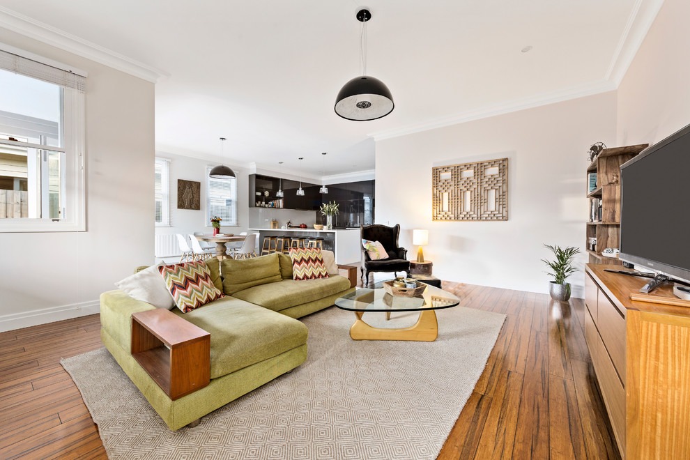 Esempio di un grande soggiorno contemporaneo aperto con pavimento in legno massello medio, pareti beige e TV autoportante