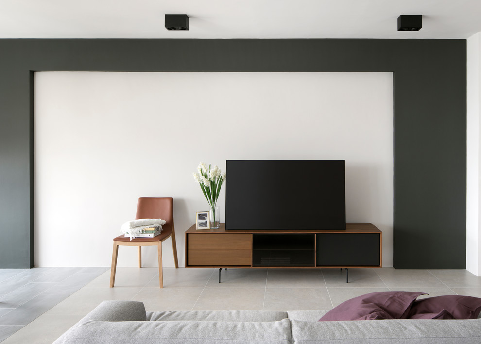 Пример оригинального дизайна: парадная, открытая гостиная комната в стиле модернизм с белыми стенами, отдельно стоящим телевизором и серым полом