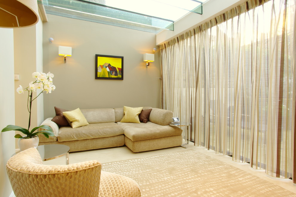 Exemple d'un salon tendance avec un mur beige.