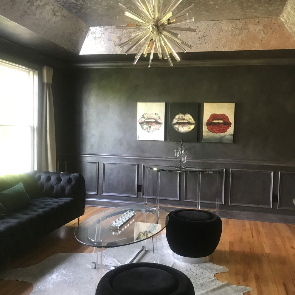 Ejemplo de salón con barra de bar cerrado, gris y gris y negro tradicional renovado grande con paredes negras, suelo de madera clara, televisor colgado en la pared, suelo marrón y bandeja