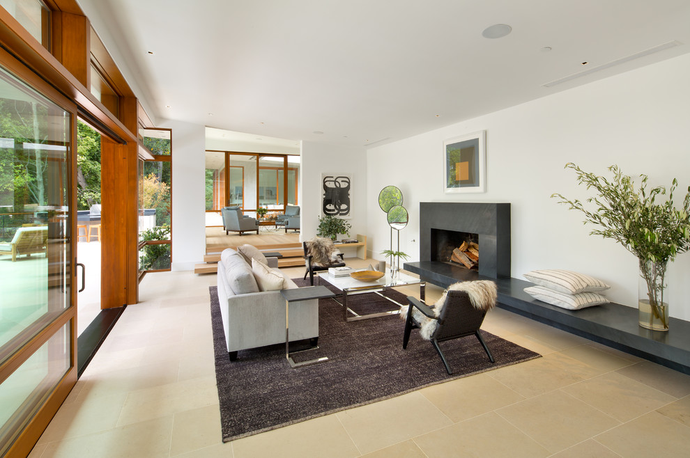 На фото: открытая гостиная комната в современном стиле с белыми стенами, горизонтальным камином и ковром на полу