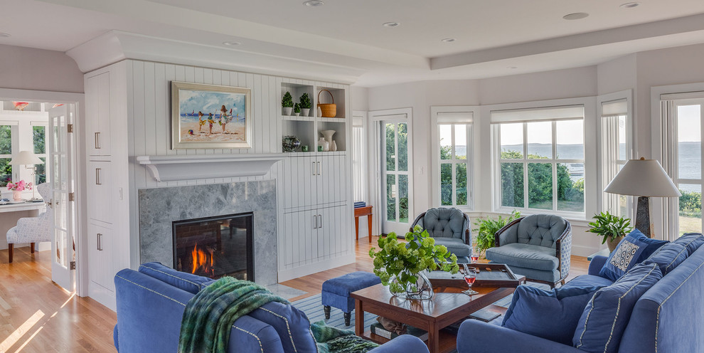 This is an example of a large nautical living room in Boston with light hardwood flooring, a standard fireplace and a stone fireplace surround.