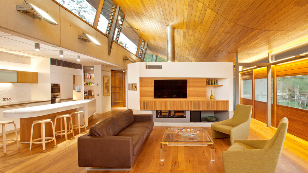 Mittelgroßes, Offenes Modernes Wohnzimmer mit weißer Wandfarbe, braunem Holzboden, Tunnelkamin und TV-Wand in Sydney
