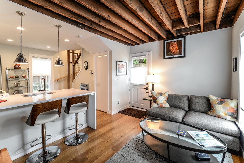 Kleines, Repräsentatives Rustikales Wohnzimmer ohne Kamin, im Loft-Stil mit grauer Wandfarbe, braunem Holzboden, TV-Wand und braunem Boden in Detroit