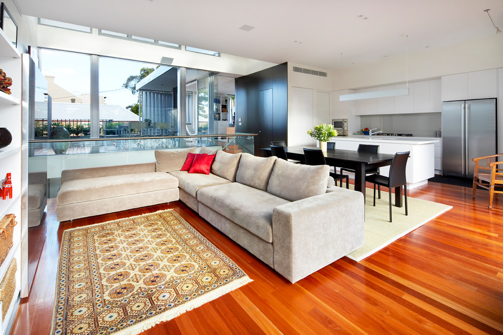 Immagine di un soggiorno design di medie dimensioni e aperto con pareti bianche, pavimento in legno massello medio e pavimento marrone