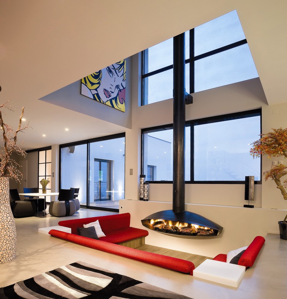 На фото: открытая гостиная комната в современном стиле с белыми стенами, подвесным камином и ковром на полу с