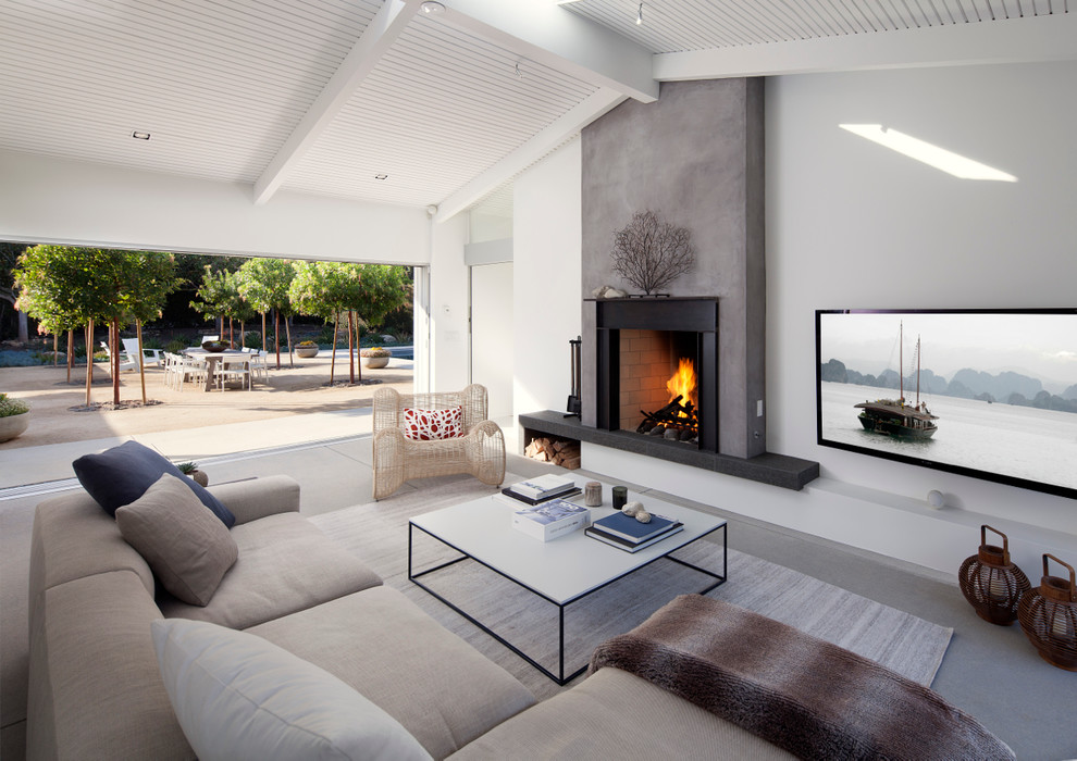 Inredning av ett minimalistiskt vardagsrum, med vita väggar, en standard öppen spis och en väggmonterad TV