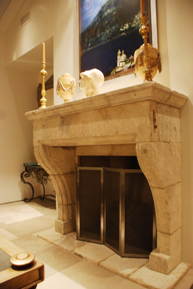 Inspiration pour un salon méditerranéen avec un sol en calcaire et un manteau de cheminée en pierre.