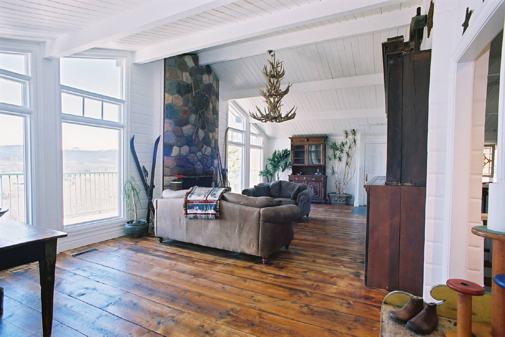Mountain style living room photo in Calgary with a stone fireplace