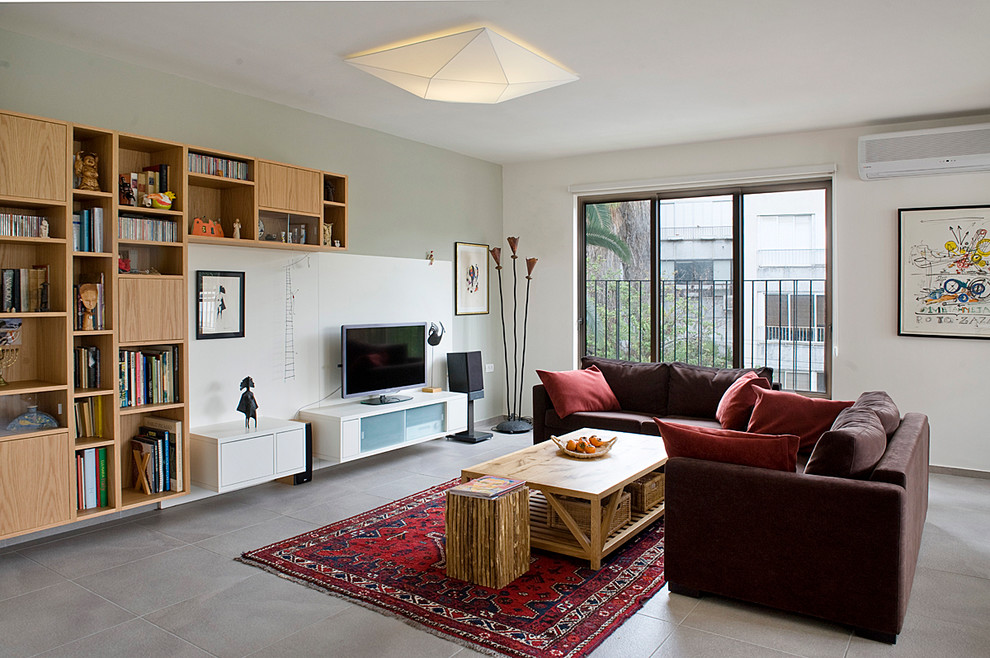 Стильный дизайн: гостиная комната в современном стиле с с книжными шкафами и полками и коричневым диваном - последний тренд