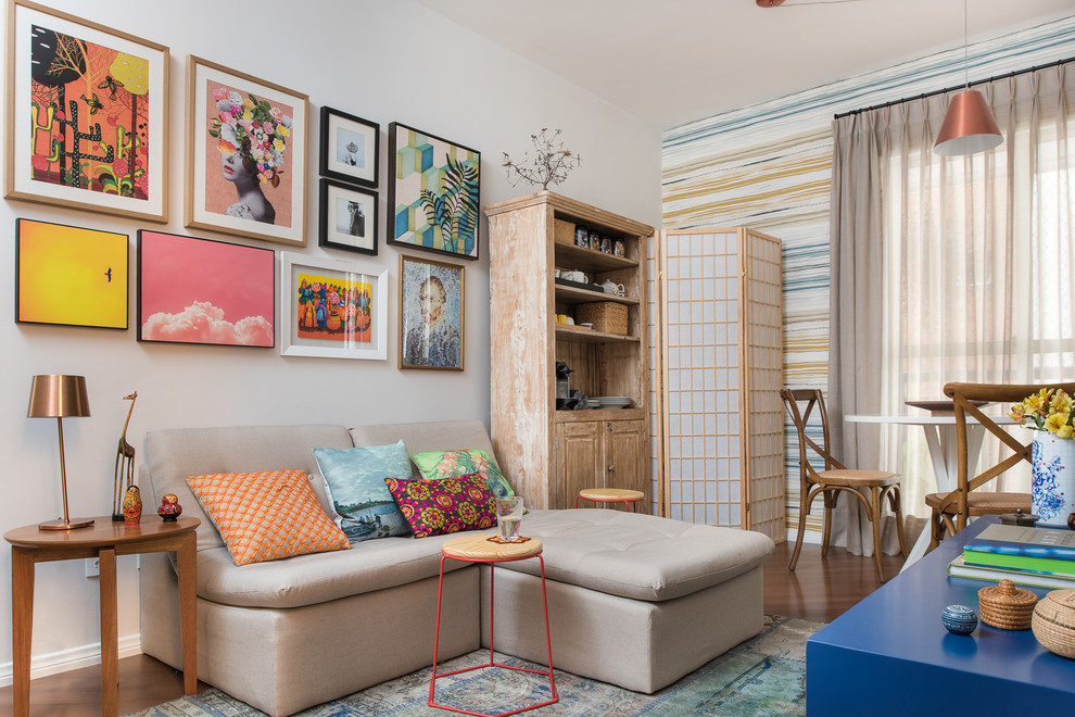 На фото: маленькая парадная, изолированная гостиная комната в стиле фьюжн с разноцветными стенами и телевизором на стене для на участке и в саду с