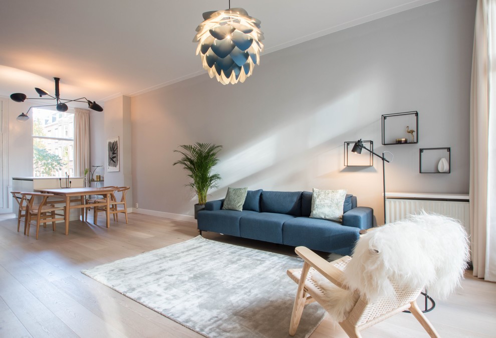 На фото: маленькая открытая гостиная комната в скандинавском стиле с серыми стенами, светлым паркетным полом и отдельно стоящим телевизором для на участке и в саду с