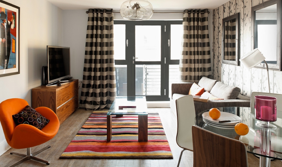 На фото: маленькая открытая гостиная комната в стиле модернизм с серыми стенами, темным паркетным полом и отдельно стоящим телевизором для на участке и в саду с