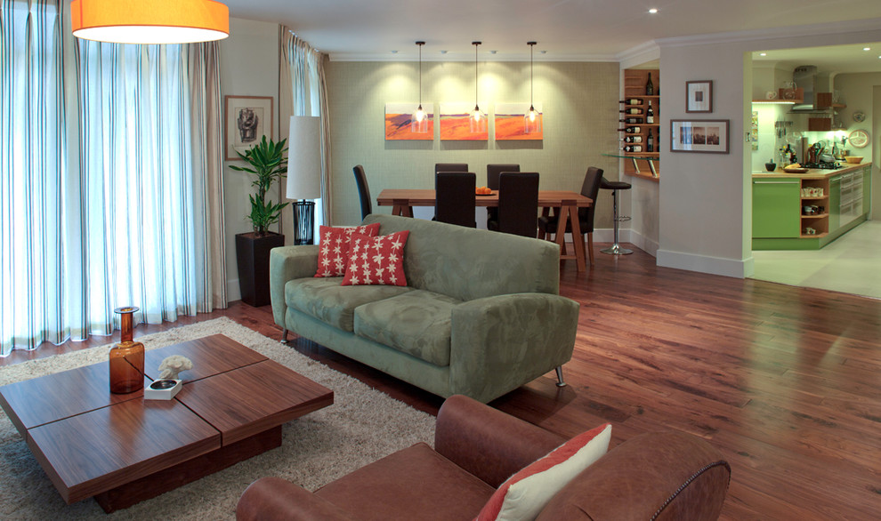 Imagen de salón abierto contemporáneo de tamaño medio con paredes beige, suelo de madera oscura y televisor independiente