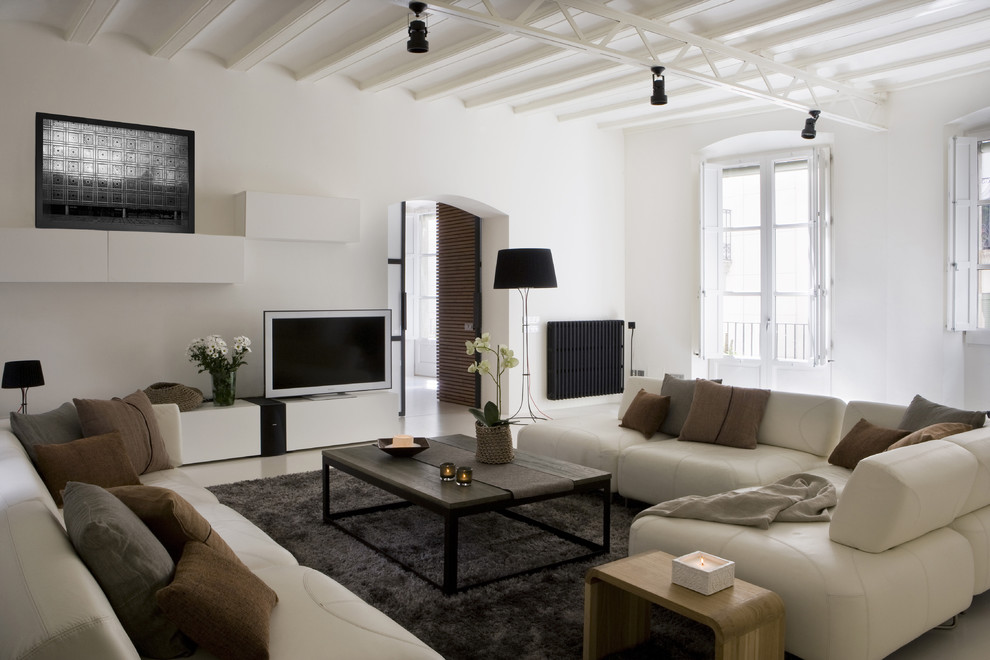 Bild på ett stort funkis vardagsrum, med vita väggar och en fristående TV