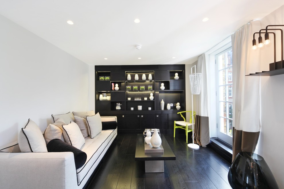 Large trendy dark wood floor and black floor living room photo in London with white walls