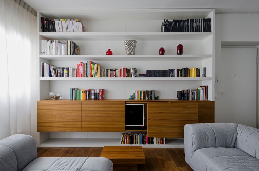 Idee per un soggiorno design di medie dimensioni e aperto con libreria, pareti bianche, pavimento in legno massello medio, nessun camino e TV nascosta