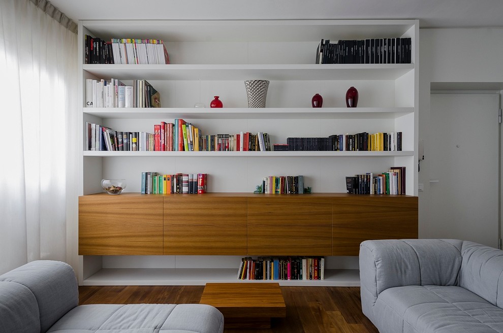 Esempio di un soggiorno contemporaneo di medie dimensioni e aperto con libreria, pareti bianche, pavimento in legno massello medio e nessun camino
