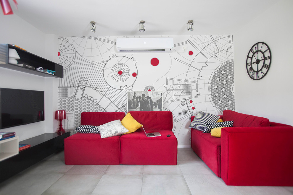 Modern inredning av ett mellanstort loftrum, med röda väggar, betonggolv och en väggmonterad TV