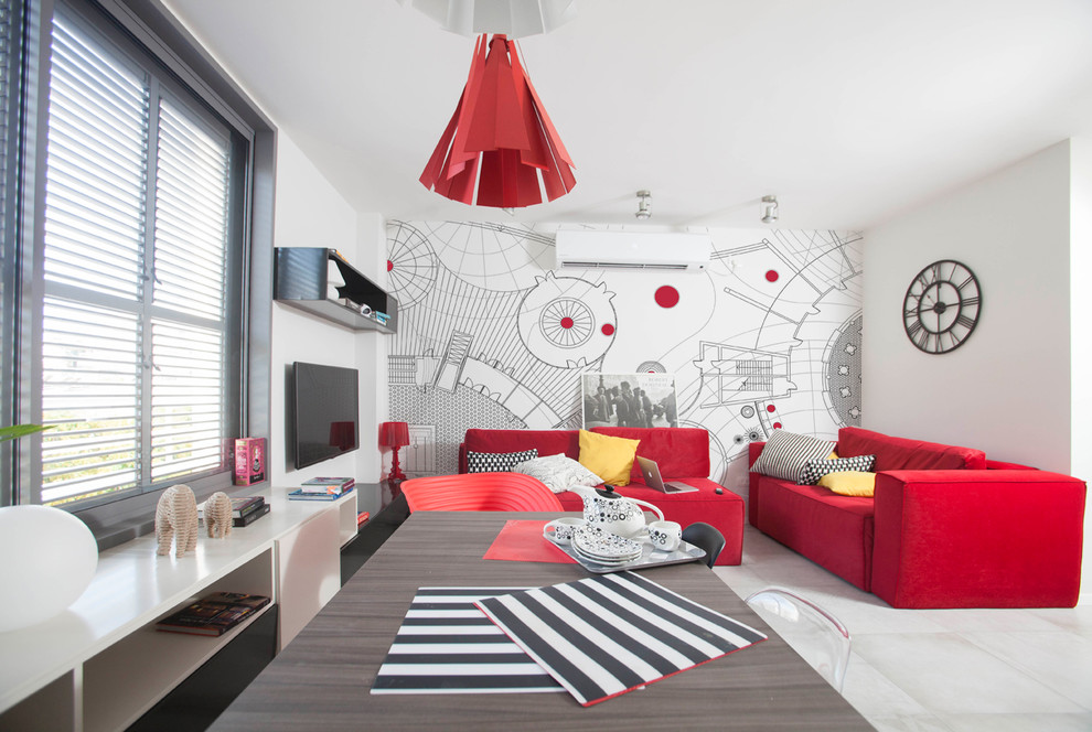 Ejemplo de salón tipo loft moderno de tamaño medio con paredes rojas, suelo de cemento y televisor colgado en la pared