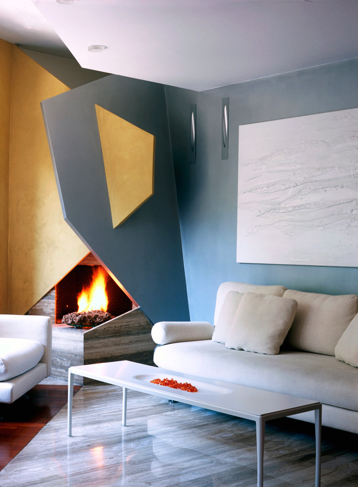 На фото: гостиная комната в современном стиле с синими стенами, мраморным полом и фасадом камина из штукатурки