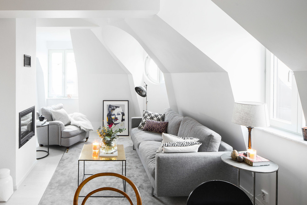 Medium sized scandinavian enclosed living room in Stockholm with white walls, light hardwood flooring, a standard fireplace and no tv.