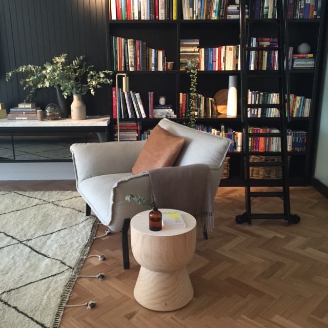 Immagine di un soggiorno minimalista di medie dimensioni e aperto con libreria, pareti marroni, parquet chiaro e TV a parete