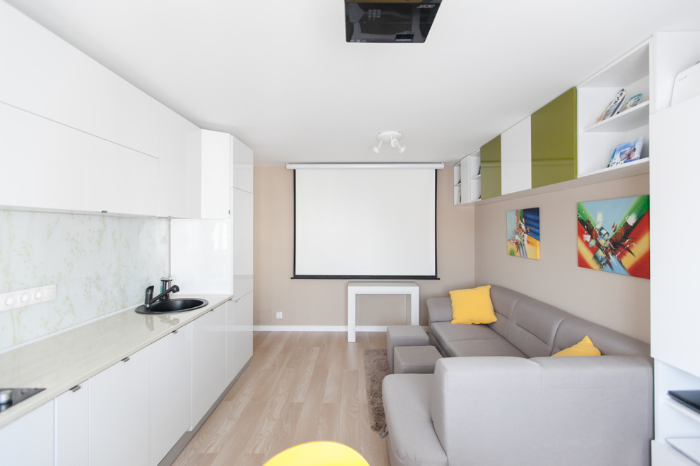 Modelo de salón abierto contemporáneo pequeño sin chimenea con paredes beige, suelo de madera clara y televisor independiente