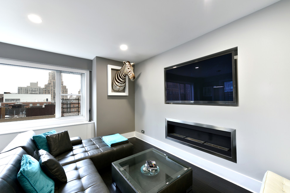 На фото: открытая гостиная комната среднего размера в современном стиле с серыми стенами, темным паркетным полом, фасадом камина из металла, горизонтальным камином и телевизором на стене