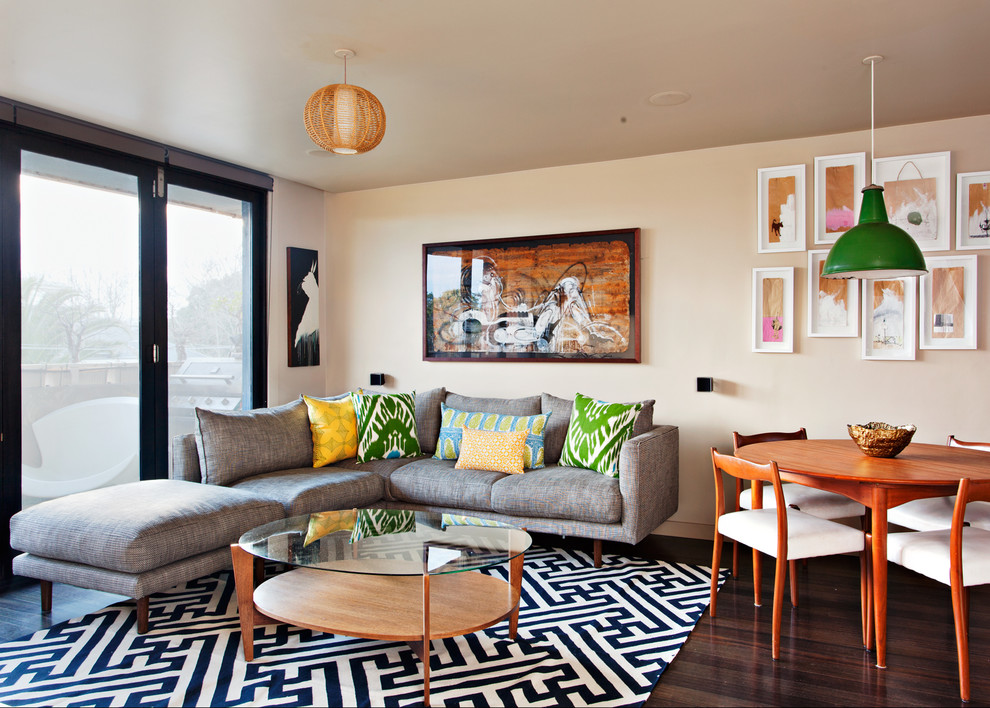 Immagine di un piccolo soggiorno moderno aperto con pareti beige e parquet scuro