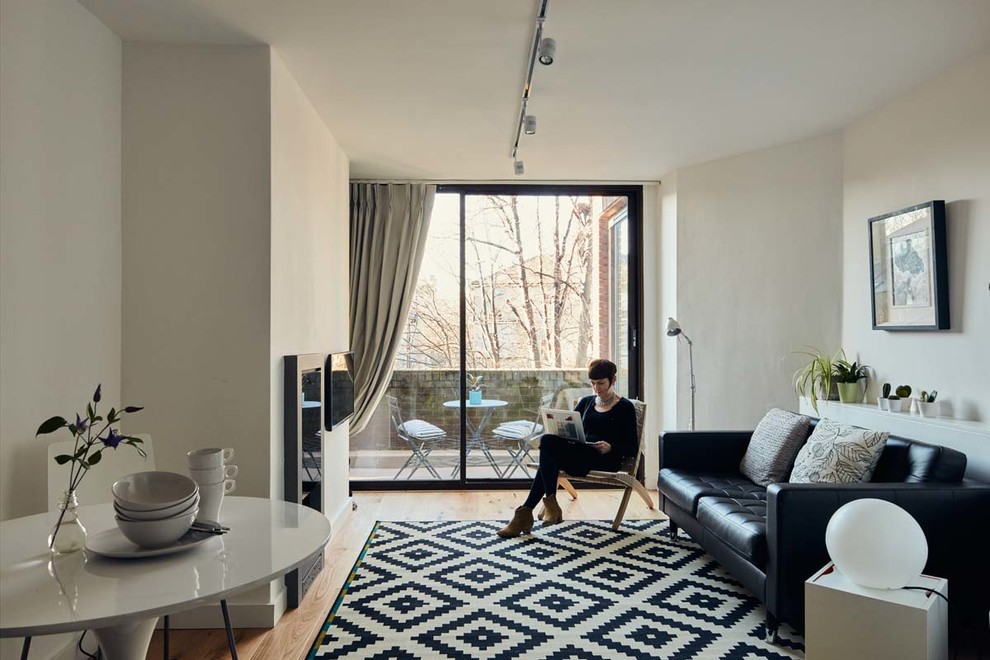 Idées déco pour un salon contemporain ouvert avec un mur blanc, un sol en bois brun, une cheminée standard, un manteau de cheminée en métal et un téléviseur fixé au mur.