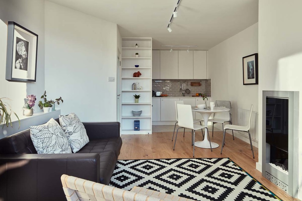 Idées déco pour un petit salon contemporain ouvert avec un mur blanc, un sol en bois brun et un téléviseur fixé au mur.