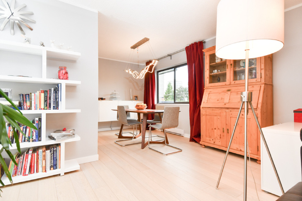 Modelo de salón minimalista grande con paredes grises, suelo de madera clara y televisor colgado en la pared