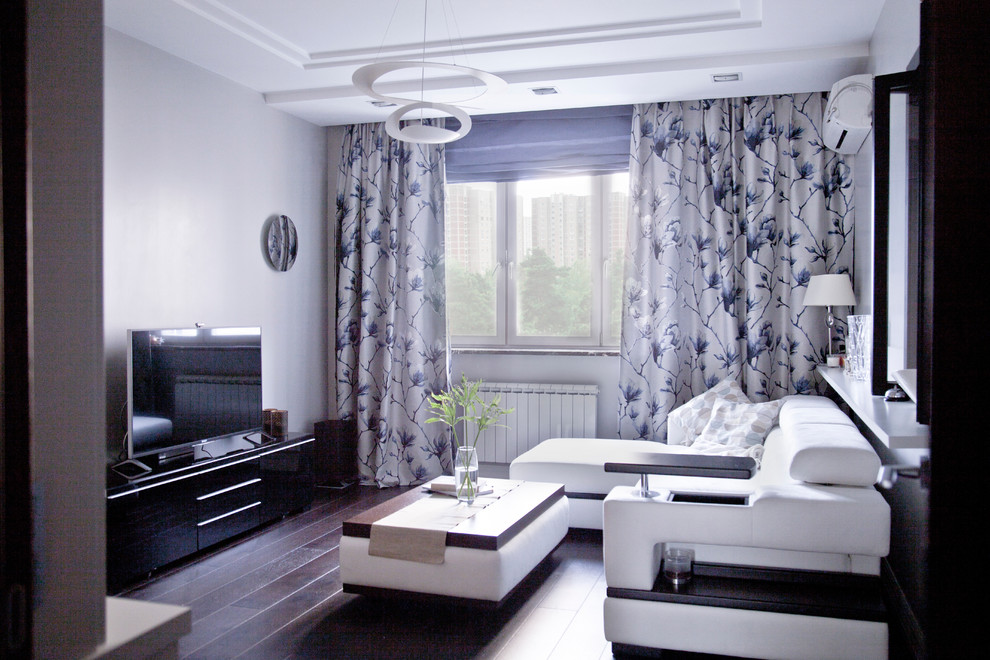 На фото: маленькая изолированная гостиная комната в современном стиле с темным паркетным полом, коричневым полом и отдельно стоящим телевизором для на участке и в саду с