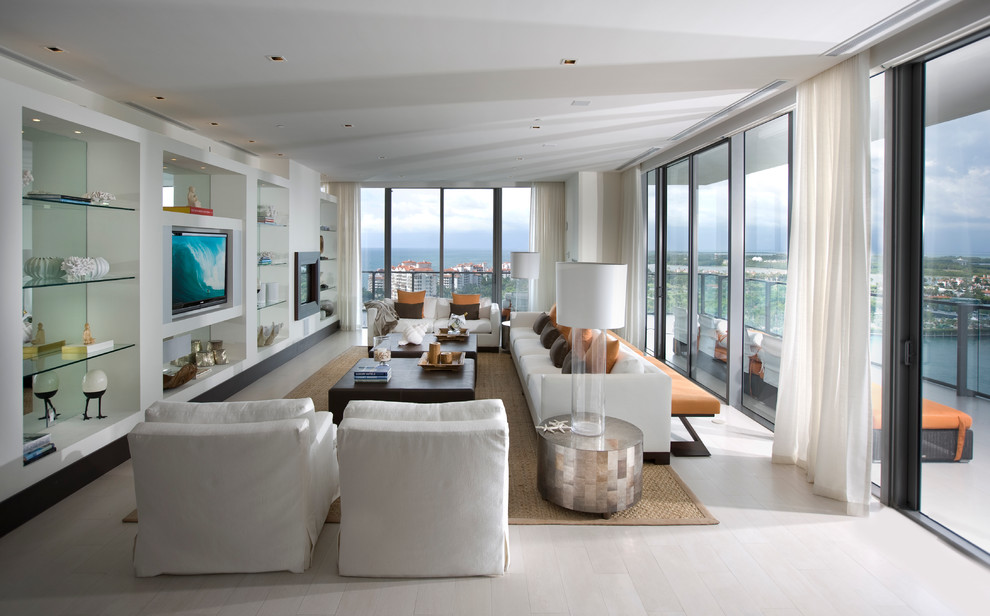 Стильный дизайн: гостиная комната в современном стиле с белыми стенами, светлым паркетным полом, стандартным камином и телевизором на стене - последний тренд