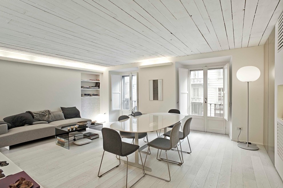 На фото: гостиная комната в современном стиле с белыми стенами и деревянным полом