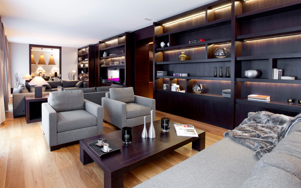 Foto de salón abierto moderno extra grande con suelo de madera clara, paredes blancas y televisor independiente