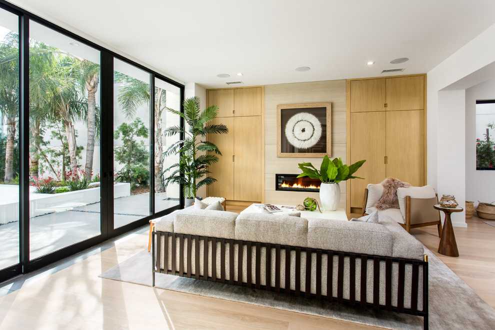 Стильный дизайн: парадная, открытая гостиная комната среднего размера в современном стиле с белыми стенами, светлым паркетным полом, горизонтальным камином, фасадом камина из металла и бежевым полом без телевизора - последний тренд