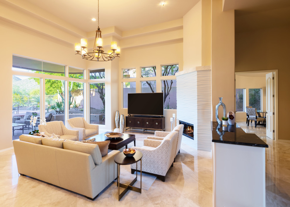 Large classic open plan living room in Phoenix with beige walls, marble flooring, a corner fireplace, a plastered fireplace surround, a freestanding tv and beige floors.