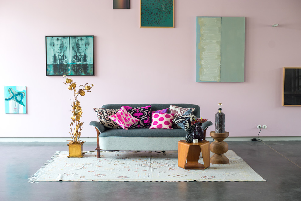 Exemple d'un salon éclectique avec un mur rose et un sol gris.